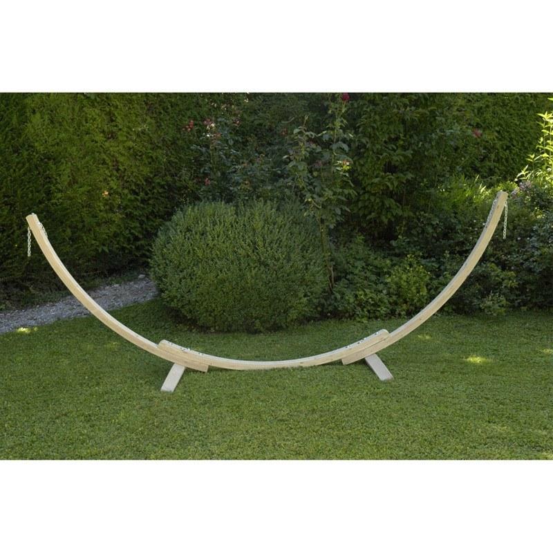 The Apollo & Marine Hammock Set by Amazonas features a curved wooden stand made from sustainable European Spruce, elegantly placed on a green lawn amidst lush greenery and small bushes, making it a striking centerpiece for any garden.