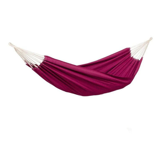 An Arte Vino Hammock from Amazonas, featuring red fabric with white strings, is hanging against a plain white background. The material gathers elegantly at the ends, forming a relaxed curve that is ideal for enjoying cozy moments in any garden setting.