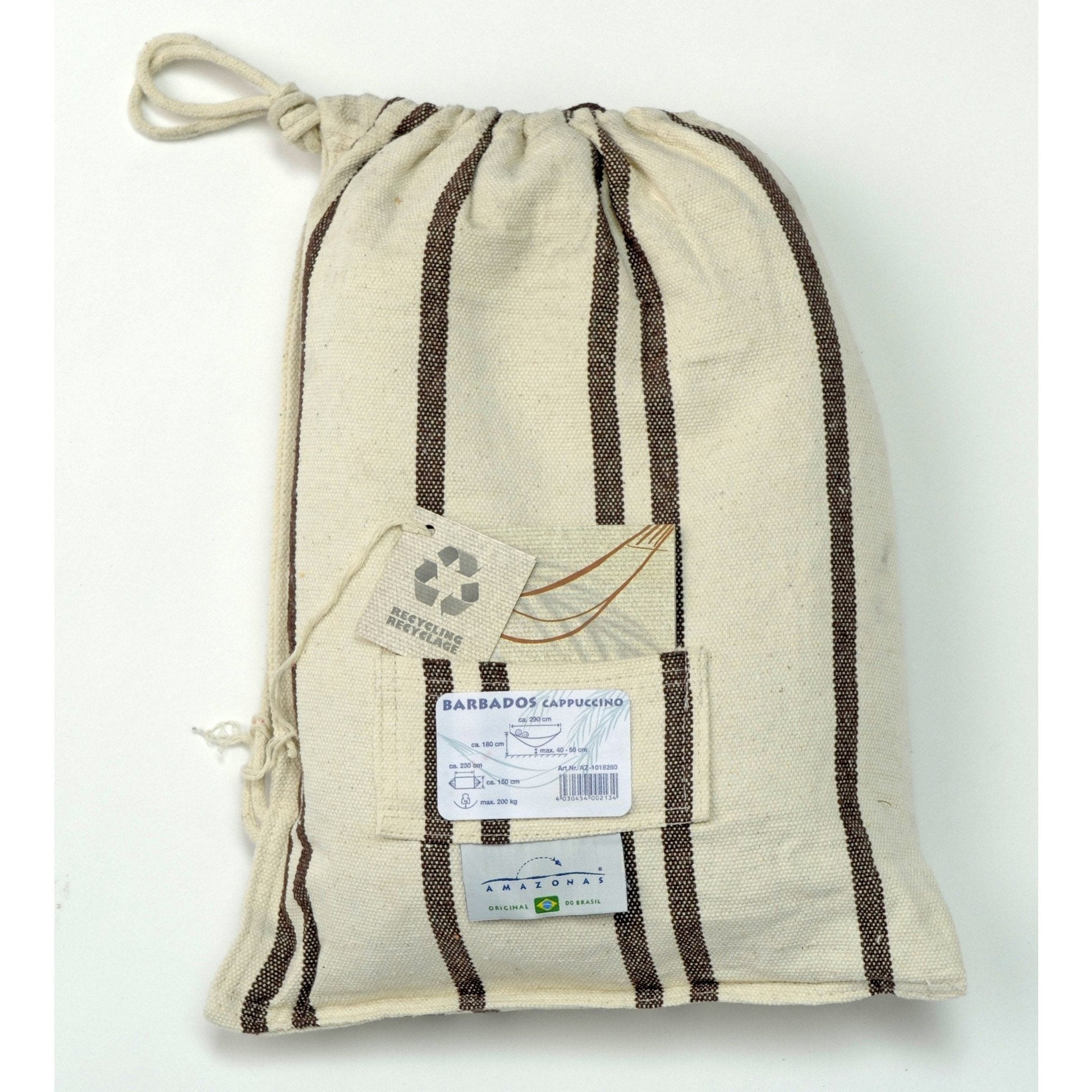 A beige drawstring bag with brown stripes, showcasing a label that reads Amazonas Barbados Cappuccino Hammock and adorned with a small recycling symbol tag. Made from Brazilian cotton, it includes a front pocket and sits against a light background.