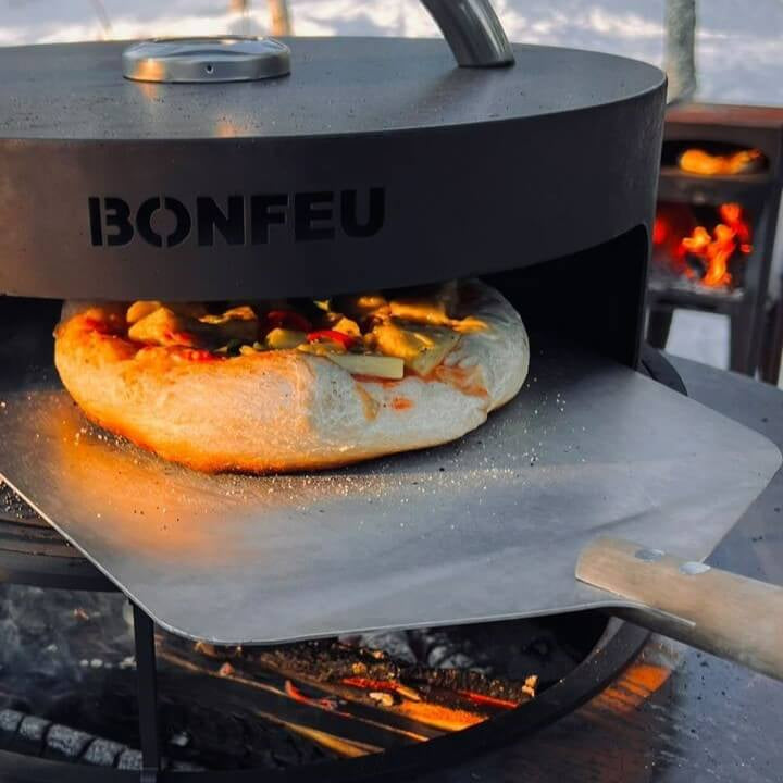 BonFeu BonPizza Oven with Stone-Bonfeu accessories-Bonfeu-BonPizza If there is one outdoor cooking unit that is super popular these days, it is the pizza oven. As it is wood-fired, the BonFeu BonBiza and BonBowl cooking unit lends itself perfectly to making the most delicious pizzas. Let the pizza oven heat up and prepare your pizza in the meantime. You open the oven by lifting or turning the lid until the pizza oven shows an opening. Now you can slide your pizza into the oven with a pizza scoop and watch t