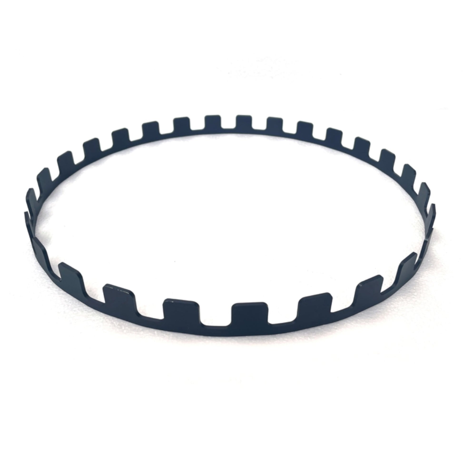 A sleek, black circular BonFeu Skewers Ring featuring evenly spaced rectangular notches along its outer edge, set against a plain white backdrop.