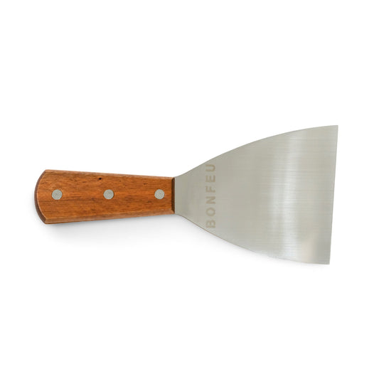 The Bonfeu Spatula features a stainless steel blade paired with a wooden handle secured by three rivets, combining durability with style. The blade is elegantly engraved with the "BONFEU" branding.