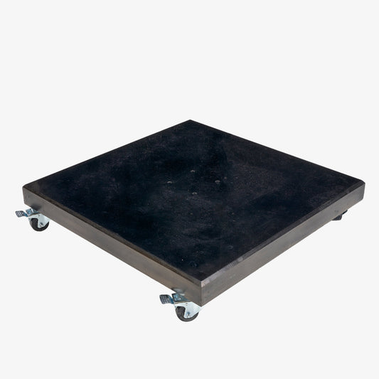 Introducing the Pacific Lifestyle Modena Polished Black Granite 120KG Parasol Base: a sleek, black rectangular platform equipped with four caster wheels for easy movement. While reminiscent of a wheeled parasol base, its robust design is perfect for transporting heavy items across flat surfaces, making it an ideal choice for industrial or warehouse applications.