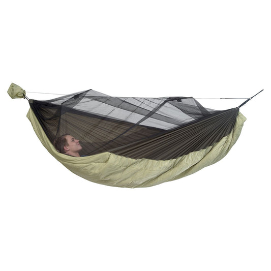 A person relaxes in the Moskito-Traveller Quilted, an ultra-light hammock by Amazonas featuring a mesh canopy that provides insect protection. This ensemble hangs securely above the ground, boasting a compact and lightweight design ideal for outdoor adventures.