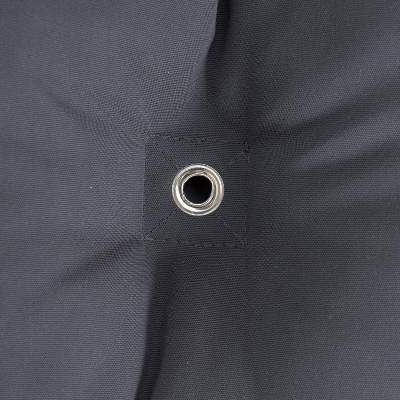 Close-up of a black, water-repellent fabric from Amazonas' The Fat Hammock - Reversible, featuring a reinforced metal eyelet at the center, surrounded by double-stitched seams. The fabric gently gathers around the eyelet, forming subtle folds—a perfect touch for those seeking luxury.