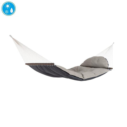 Introducing the Amazonas "The Fat Hammock - Reversible," expertly crafted with a plush grey fabric bed and a sleek black underside for those who appreciate luxury. It is elegantly suspended by white ropes and wooden spreader bars, and comes complete with a pillow at one end. An icon in the top left corner guarantees its water-repellent quality.